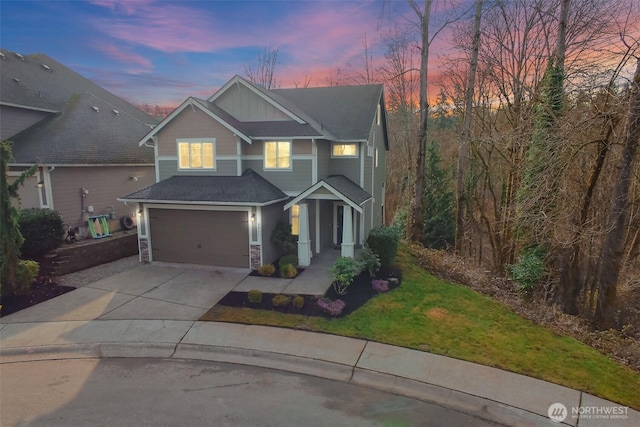 view of front of home featuring a garage, stone siding, a front yard, and driveway