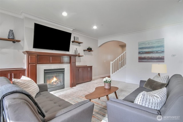 living area with stairway, carpet, arched walkways, and crown molding