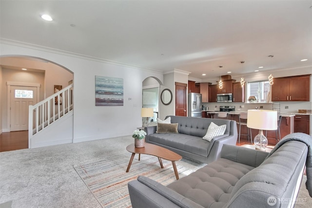 living area featuring arched walkways, ornamental molding, carpet flooring, and recessed lighting