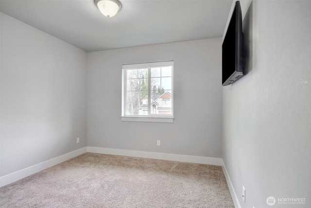 carpeted spare room featuring baseboards