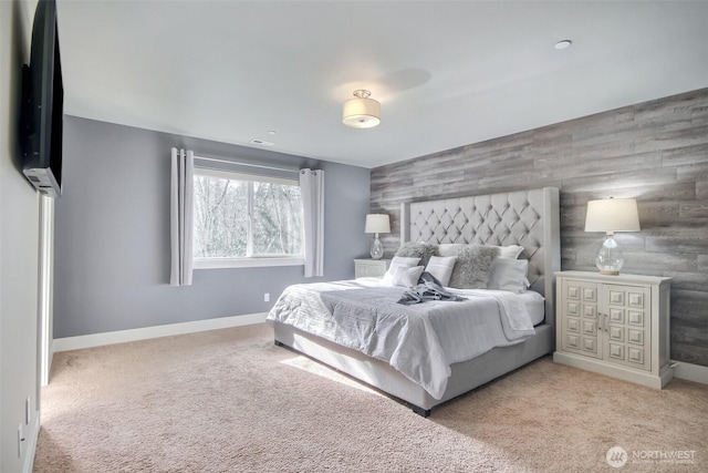 bedroom with light carpet, an accent wall, and baseboards