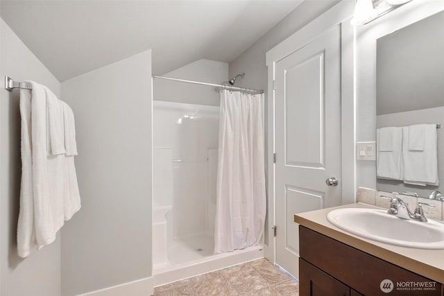 bathroom with lofted ceiling, a shower stall, and vanity
