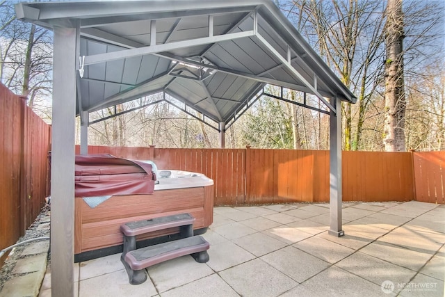 view of patio with a fenced backyard and a hot tub
