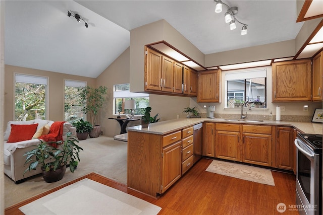 kitchen with light countertops, brown cabinets, stainless steel appliances, and a sink