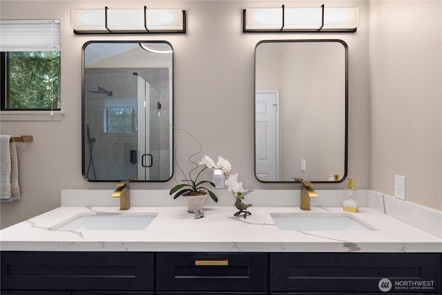 bathroom with double vanity, a shower stall, and a sink