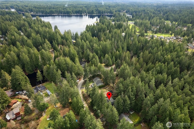 birds eye view of property with a wooded view and a water view