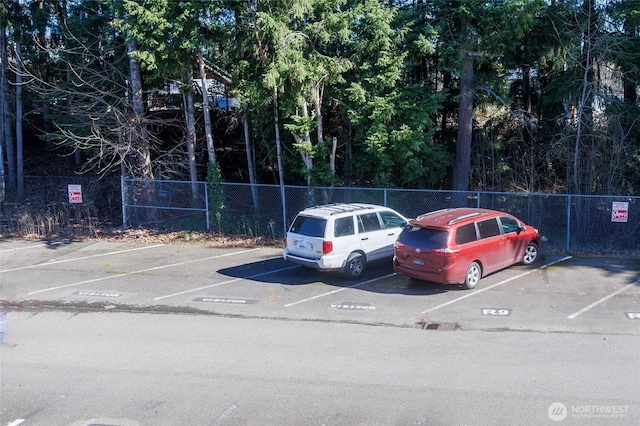 uncovered parking lot featuring fence