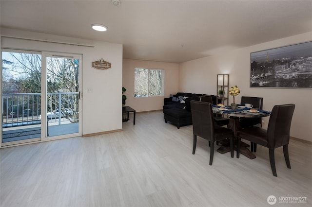 dining space featuring wood finished floors, a wealth of natural light, and baseboards