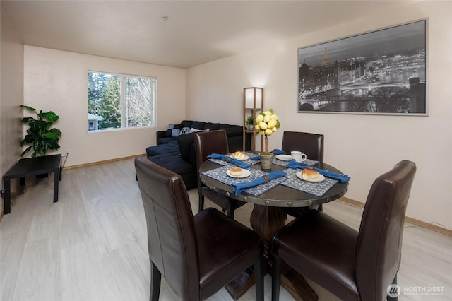 dining space with baseboards and wood finished floors