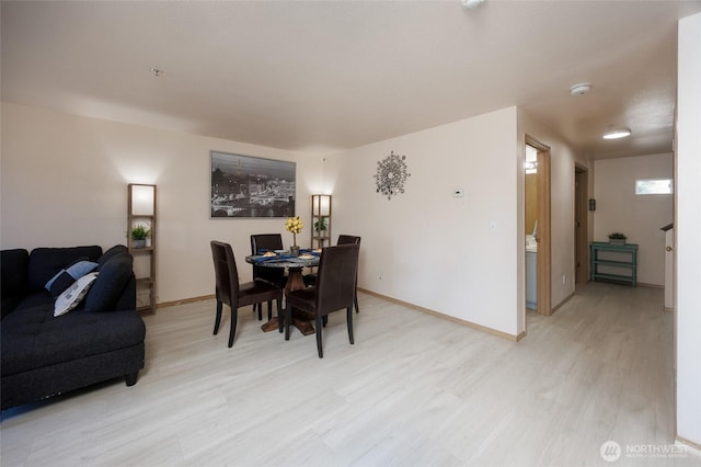 dining room with light wood finished floors and baseboards