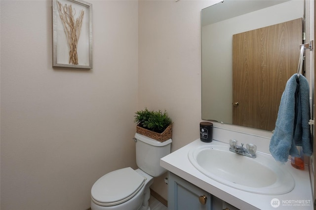 half bathroom with vanity and toilet