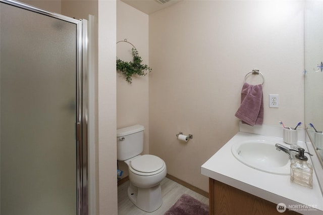 full bathroom featuring toilet, a stall shower, and vanity