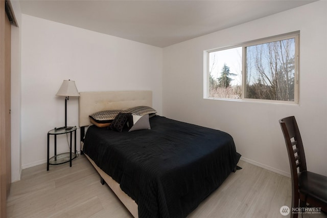 bedroom with baseboards and wood finished floors