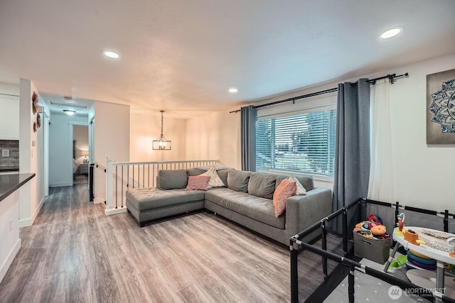 living room with recessed lighting, baseboards, and wood finished floors