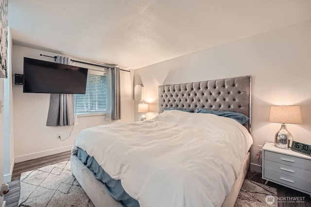 bedroom with wood finished floors and baseboards