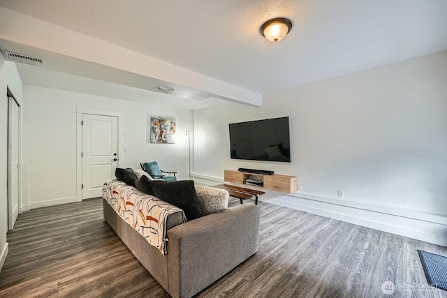 living room with dark wood finished floors, beamed ceiling, baseboards, and visible vents