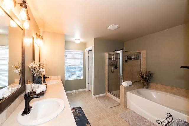 bathroom featuring a garden tub, a sink, a shower stall, and double vanity