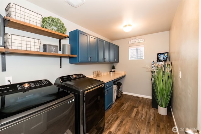 laundry room featuring dark wood-type flooring, washing machine and clothes dryer, cabinet space, and baseboards