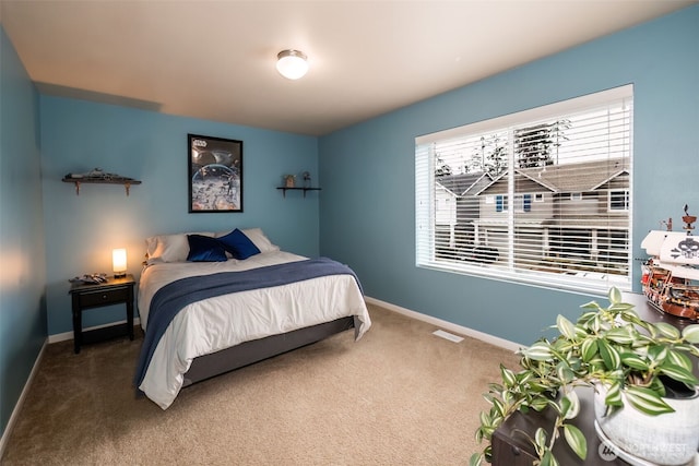 carpeted bedroom with visible vents and baseboards