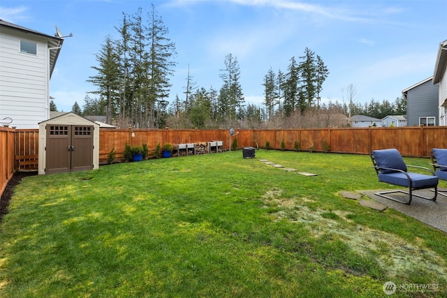 view of yard with a fenced backyard, a shed, and an outbuilding