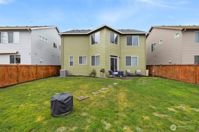 back of house featuring a fenced backyard, a yard, and central AC unit