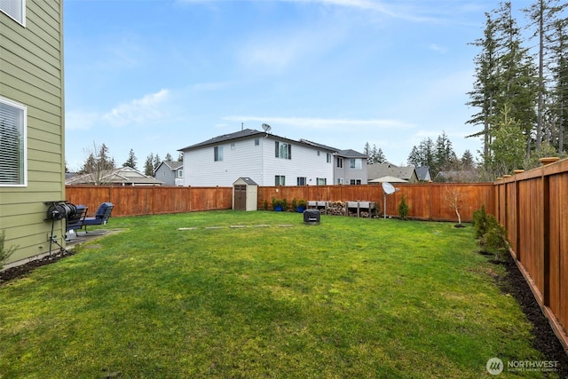 view of yard with a storage unit, an outdoor structure, and a fenced backyard