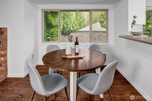 dining area with baseboards and dark wood finished floors