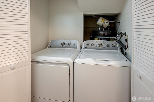 laundry room with laundry area, visible vents, and washing machine and clothes dryer