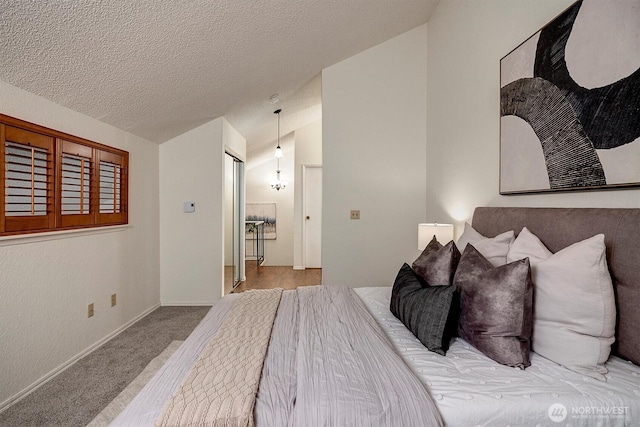 carpeted bedroom featuring vaulted ceiling, a textured ceiling, and baseboards