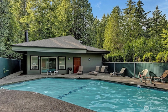 community pool with a patio area and fence