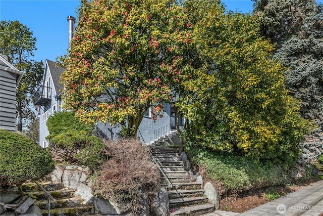 view of home's exterior featuring stairs and a shingled roof