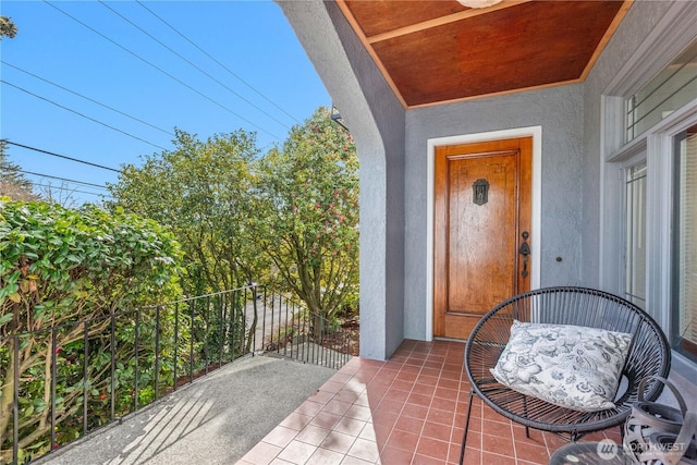 doorway to property with a balcony and stucco siding