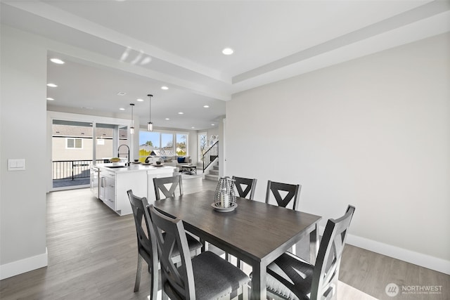 dining room featuring stairs, recessed lighting, baseboards, and wood finished floors