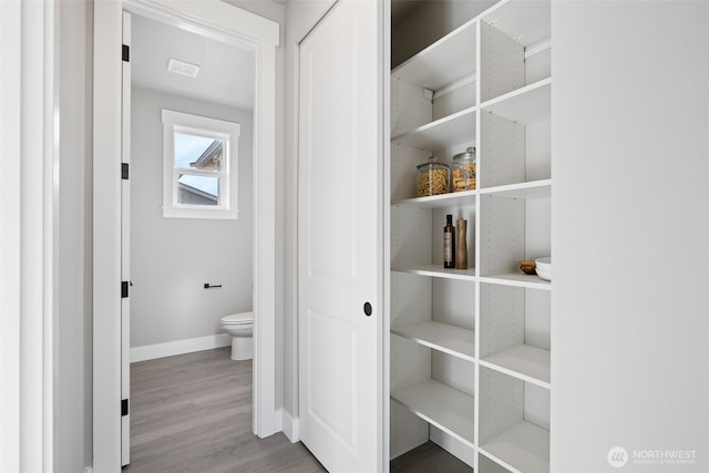 hall with wood finished floors and baseboards