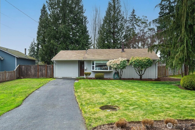 ranch-style house with aphalt driveway, a front yard, and fence