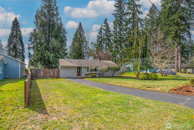 ranch-style house featuring fence, driveway, and a front lawn