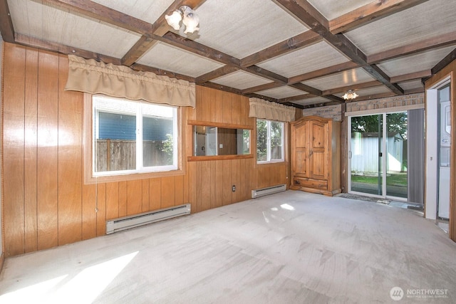 carpeted empty room featuring a baseboard heating unit, coffered ceiling, beamed ceiling, and wooden walls