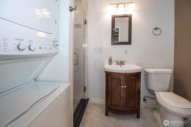 full bath featuring baseboards, toilet, stacked washer / drying machine, vanity, and a shower stall