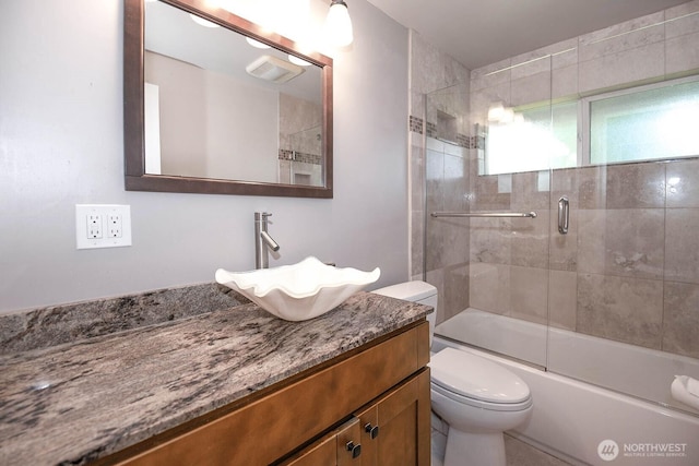 full bathroom featuring visible vents, vanity, toilet, and enclosed tub / shower combo