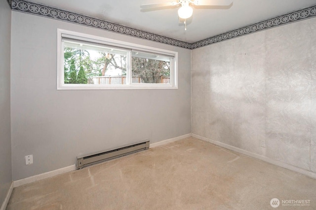 carpeted spare room featuring a baseboard heating unit, ceiling fan, and baseboards