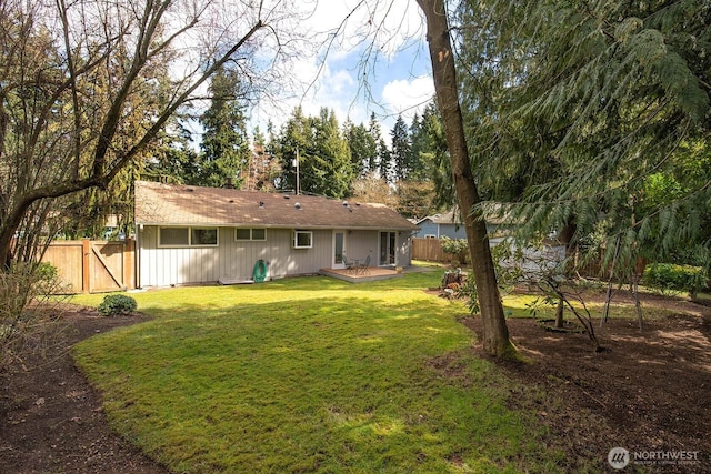 rear view of house featuring a deck, a lawn, and fence