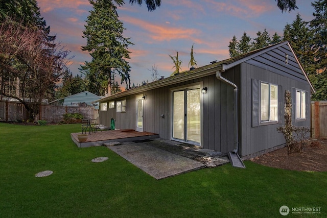 back of property featuring fence, a deck, a patio, and a yard