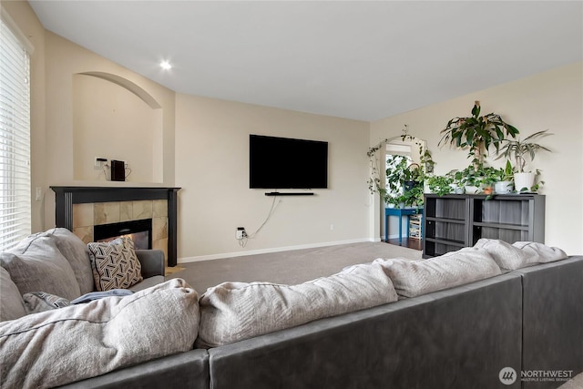 carpeted living area featuring a fireplace and baseboards