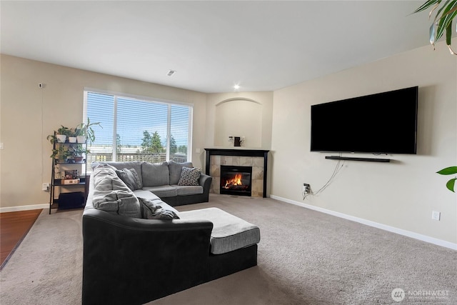 living room featuring carpet, baseboards, and a tile fireplace