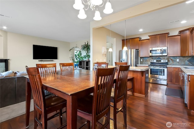 dining room featuring recessed lighting, dark wood finished floors, visible vents, and a notable chandelier