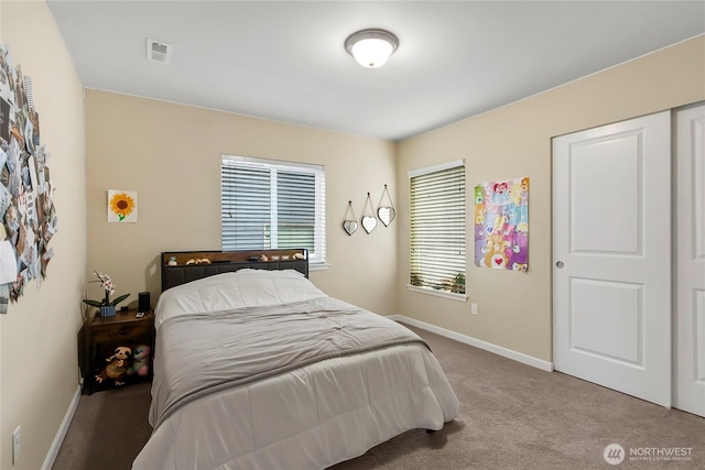 bedroom with carpet floors, visible vents, and baseboards