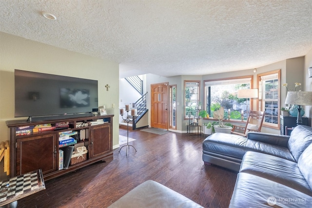 living room with stairway, baseboards, a textured ceiling, and wood finished floors