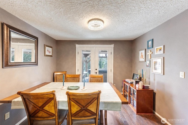 dining space with wood finished floors, french doors, baseboards, and a textured ceiling