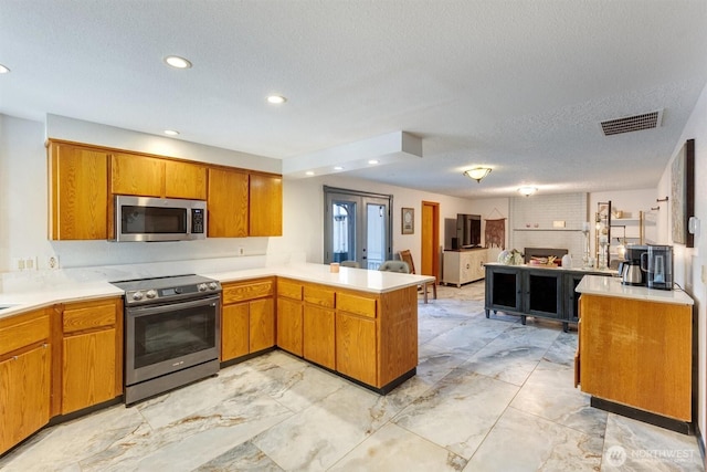 kitchen with visible vents, marble finish floor, open floor plan, stainless steel appliances, and a peninsula