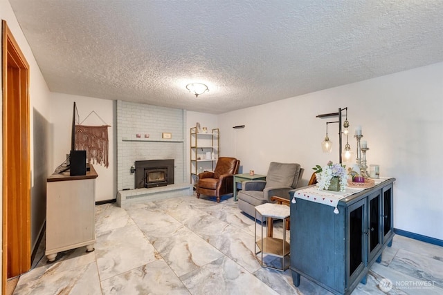 living area with marble finish floor, a fireplace, a textured ceiling, and baseboards